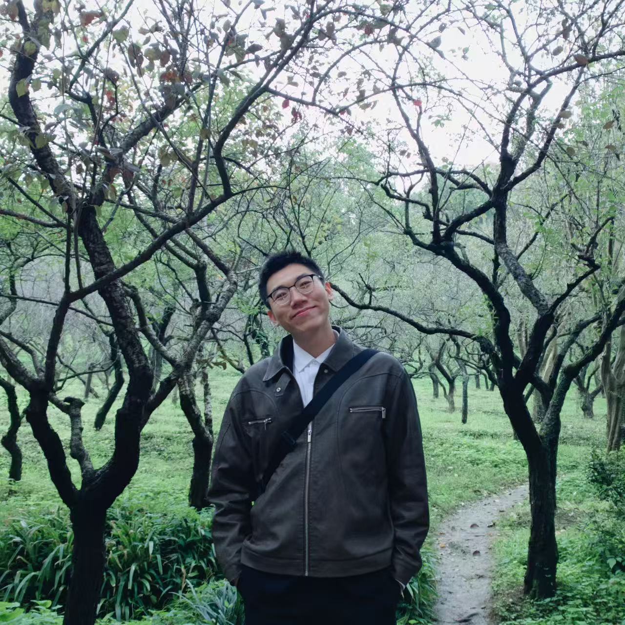 王旭东在绿树间微笑的生活照